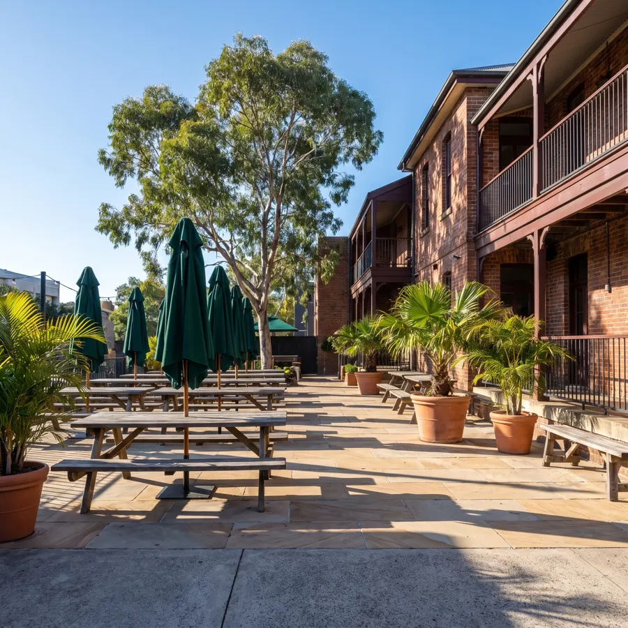 Clean pub beer garden with sandstone paving and timber tables